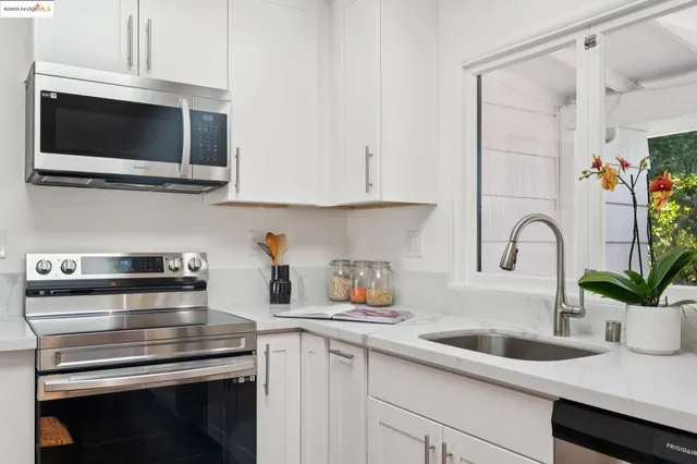 a kitchen with appliances a sink and cabinets