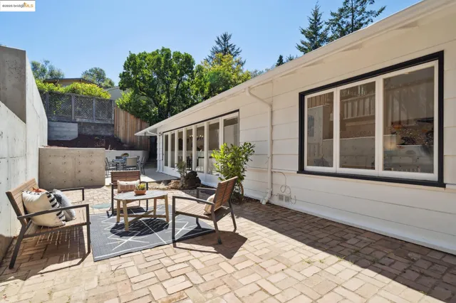 a view of a house with backyard and sitting area