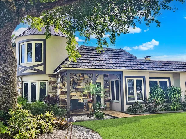 a front view of a house with a garden and plants