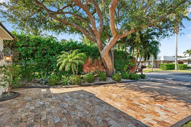 a large kitchen with stainless steel appliances kitchen island granite countertop a refrigerator and a sink