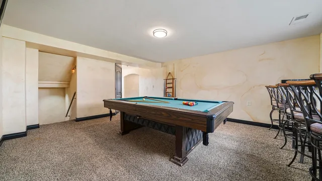 a room with furniture pool table and windows