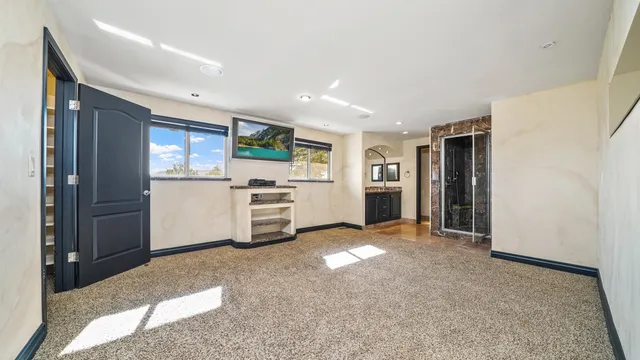 a view of a kitchen with refrigerator stove and windows
