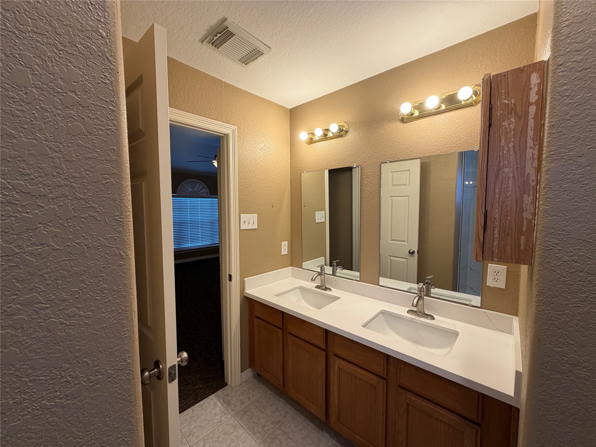9110 Prairie Trails Drive Spring, TX 77379 - Photo 14 of 34 a bathroom with a double vanity sink and a mirror
