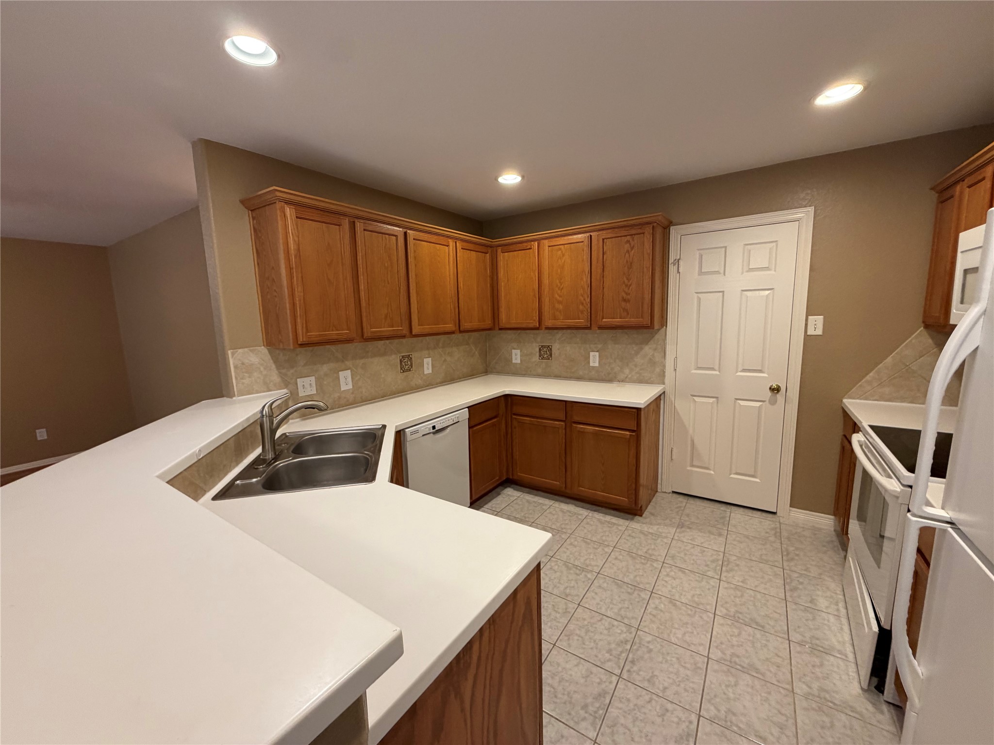 9110 Prairie Trails Drive Spring, TX 77379 - Photo 30 of 34 a kitchen that has a sink a stove and a microwave oven with wooden cabinets
