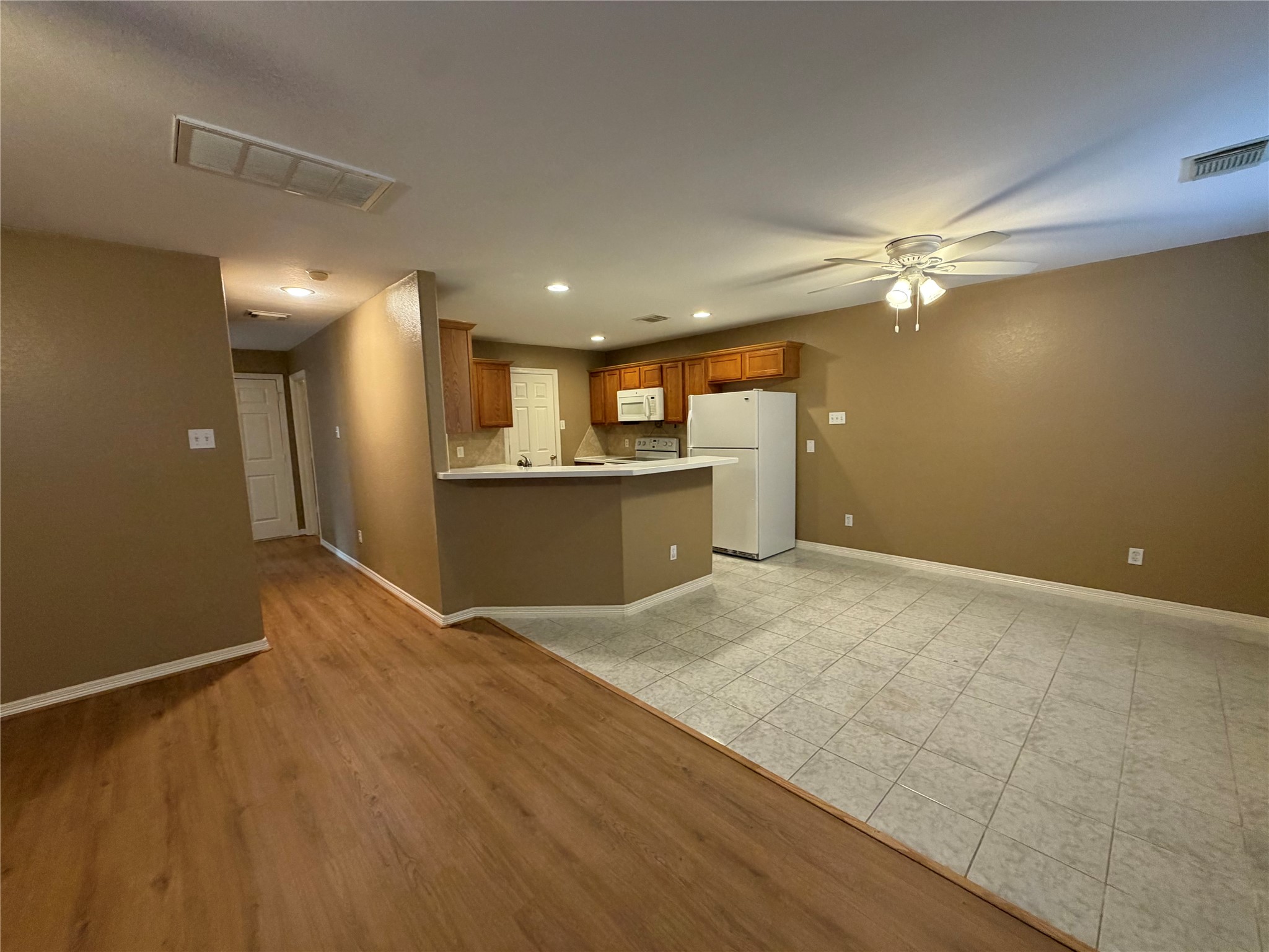 9110 Prairie Trails Drive Spring, TX 77379 - Photo 32 of 34 a view of kitchen and empty room with wooden floor
