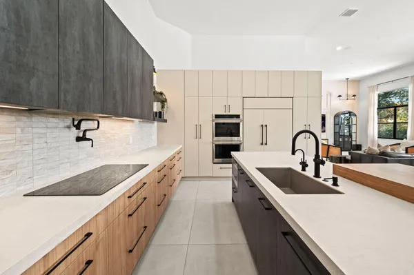 a large kitchen with stainless steel appliances granite countertop a sink and cabinets