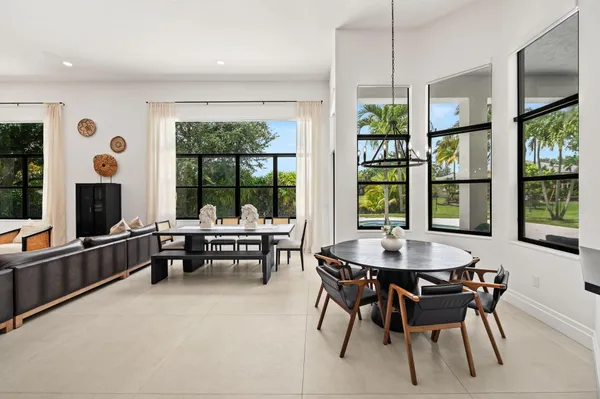 a dining room with furniture a chandelier and wooden floor