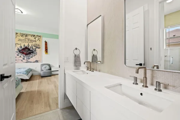 a bathroom with double vanity sinks a mirror and a shower