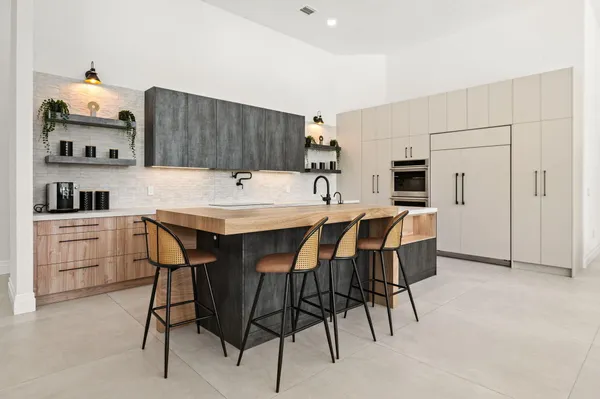 a kitchen with a dining table chairs and refrigerator
