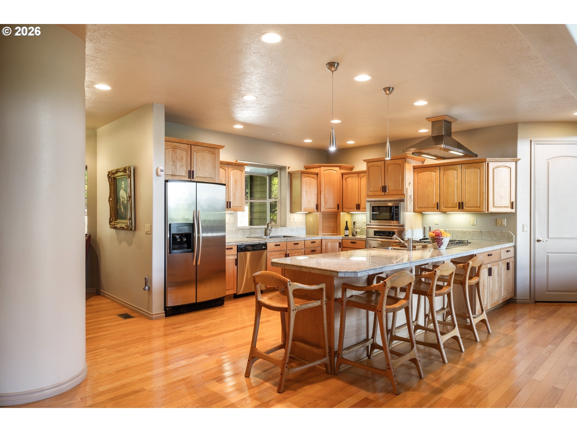 9491 Cook-Underwood Road Underwood, WA 98651 - Photo 17 of 46 a kitchen with stainless steel appliances kitchen island granite countertop a refrigerator a stove a sink a dining table and chairs