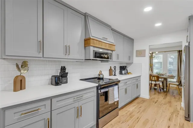 a kitchen with stainless steel appliances granite countertop a sink a stove and cabinets