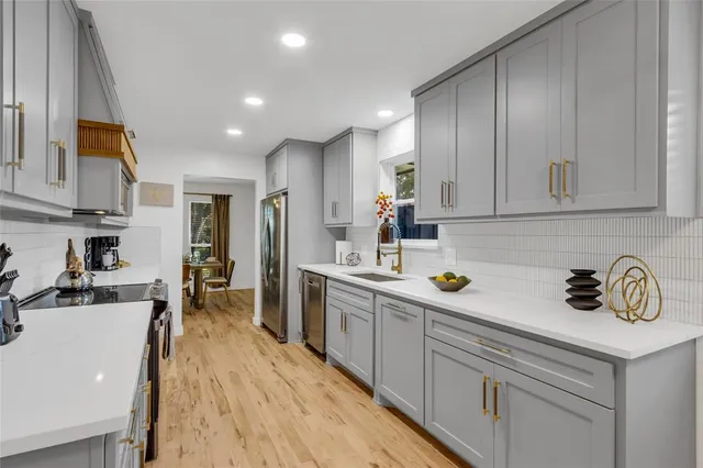 a kitchen with a sink a counter space cabinets and appliances