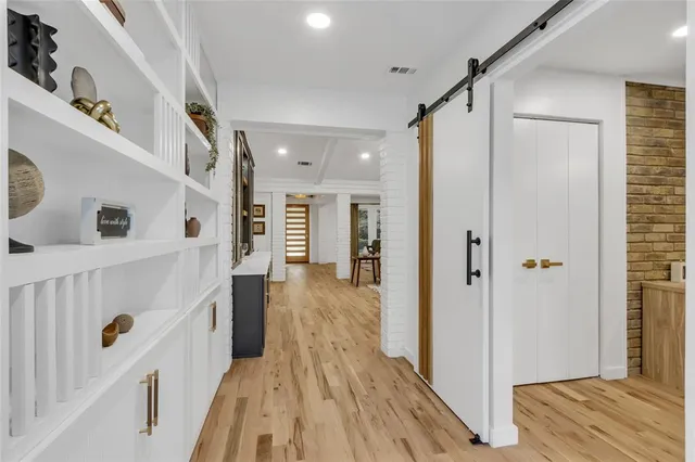 a view of a hallway with wooden floor and staircase