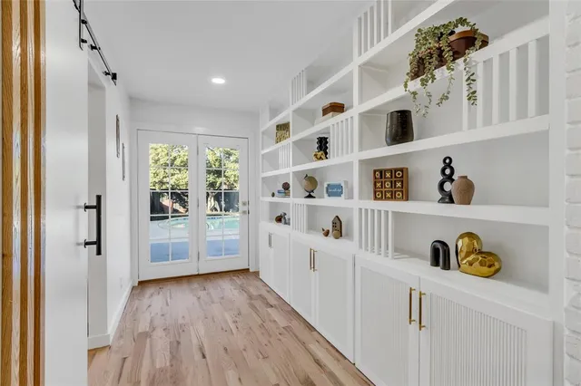 a kitchen with white cabinets and wooden floor