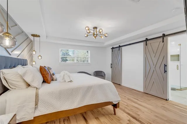 a bedroom with a large bed and a chandelier
