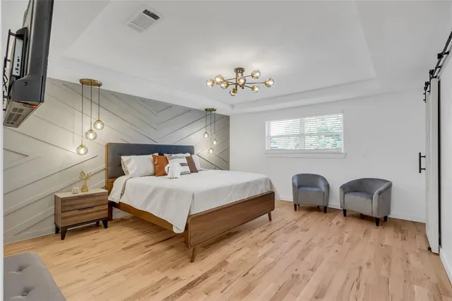 a spacious bedroom with a bed and a chandelier