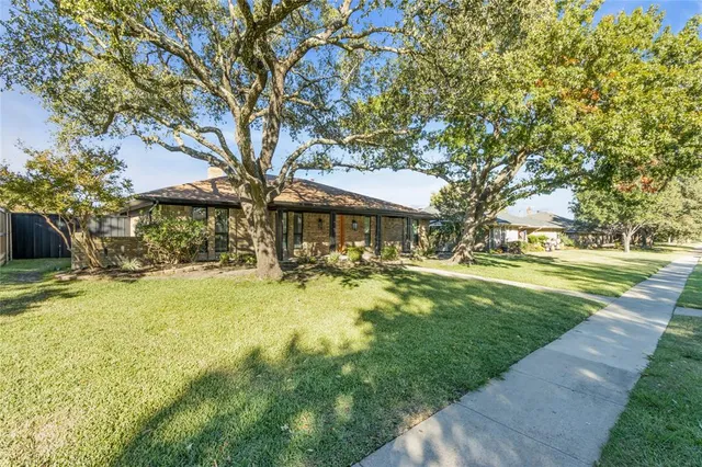 a front view of a house with yard and green space