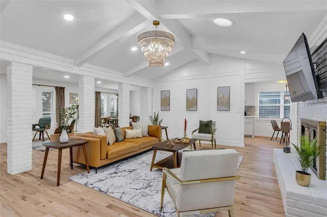 a living room with furniture chandelier and a flat screen tv