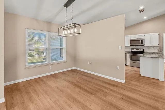 a view of a kitchen with a sink wooden floor and a refrigerator