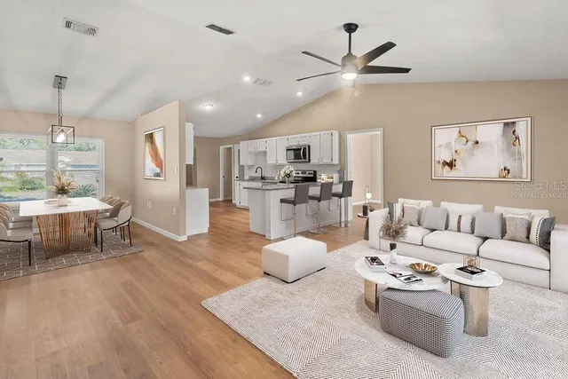 a living room with furniture and kitchen view