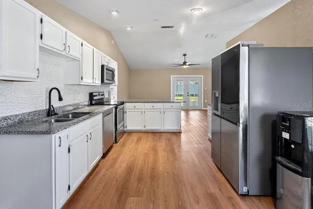 a kitchen with stainless steel appliances granite countertop a refrigerator and cabinets