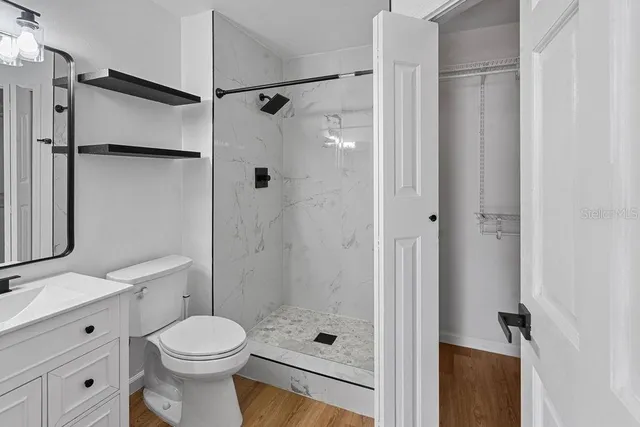 a bathroom with a sink a toilet and shower