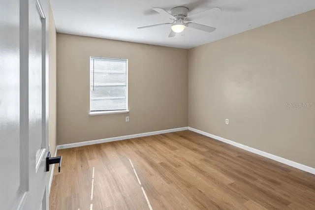 a view of an empty room with wooden floor
