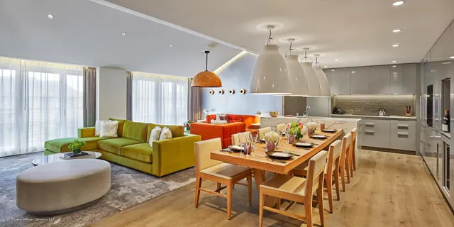 a living room with furniture a chandelier and a dining table