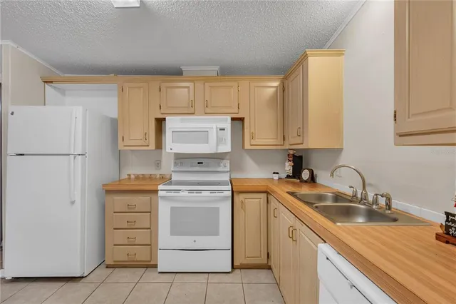 a kitchen with a refrigerator sink and cabinets