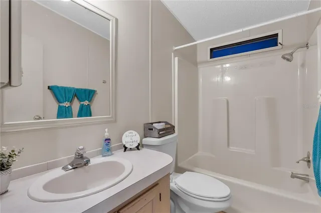 a bathroom with a sink a toilet a mirror and shower