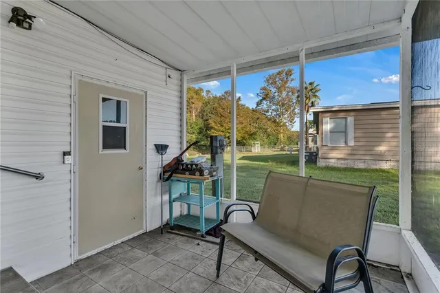a view of a porch with furniture and a yard