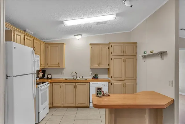 a kitchen with a sink a refrigerator and white cabinets