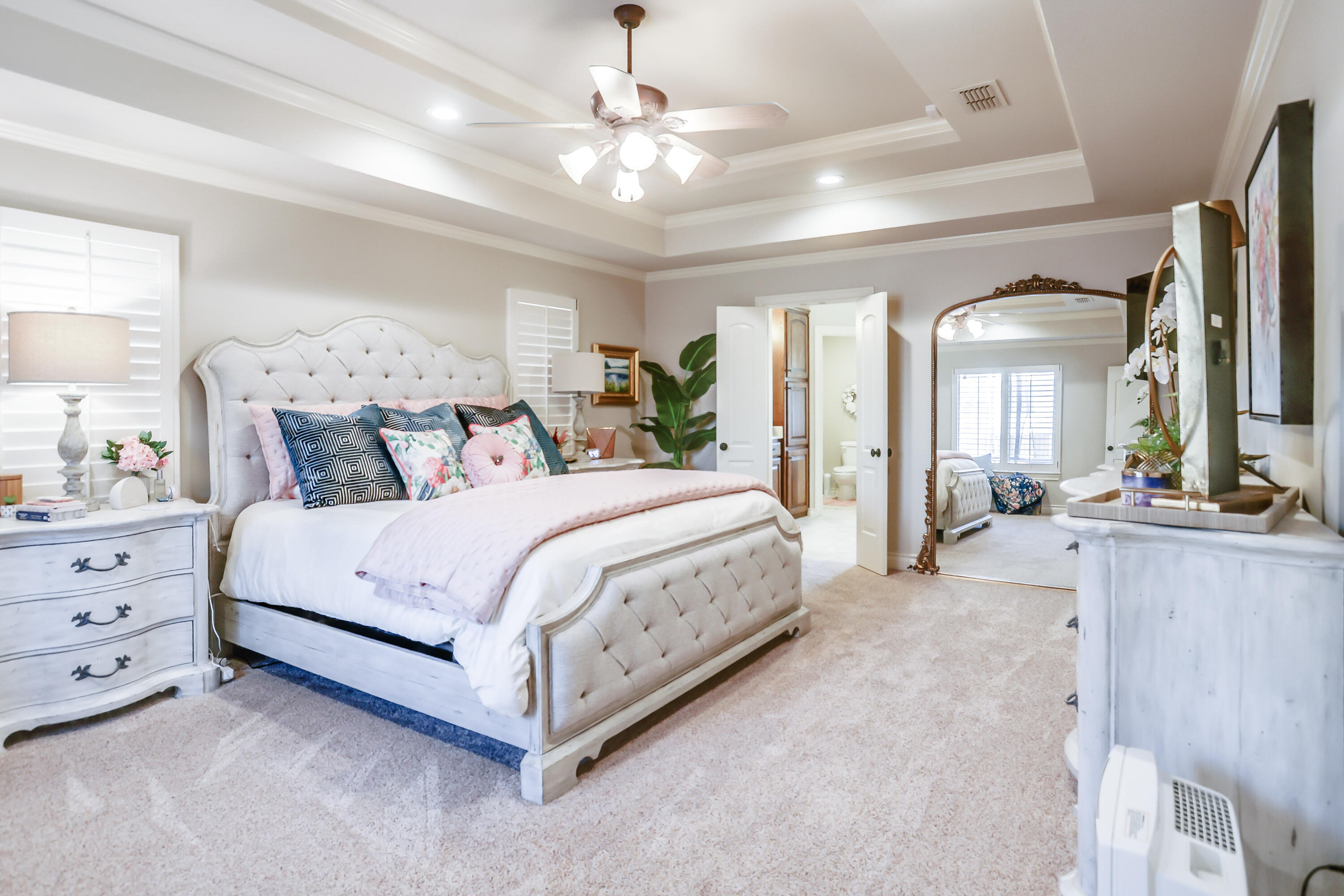 3804 103rd Street Lubbock, TX 79423 - Photo 16 of 32 a spacious bedroom with a large bed and a chandelier