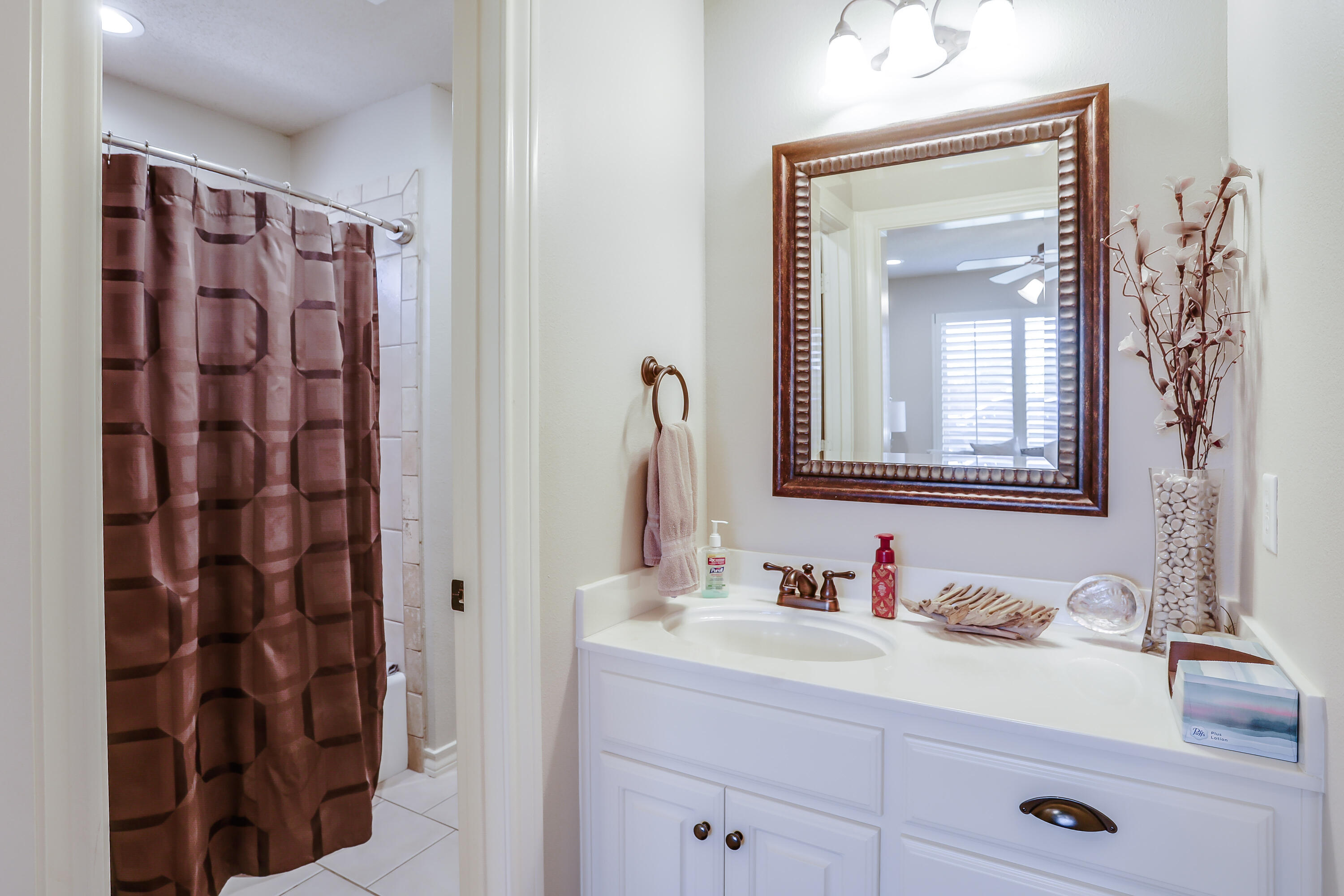 3804 103rd Street Lubbock, TX 79423 - Photo 21 of 32 a bathroom with a granite countertop sink a mirror and shower
