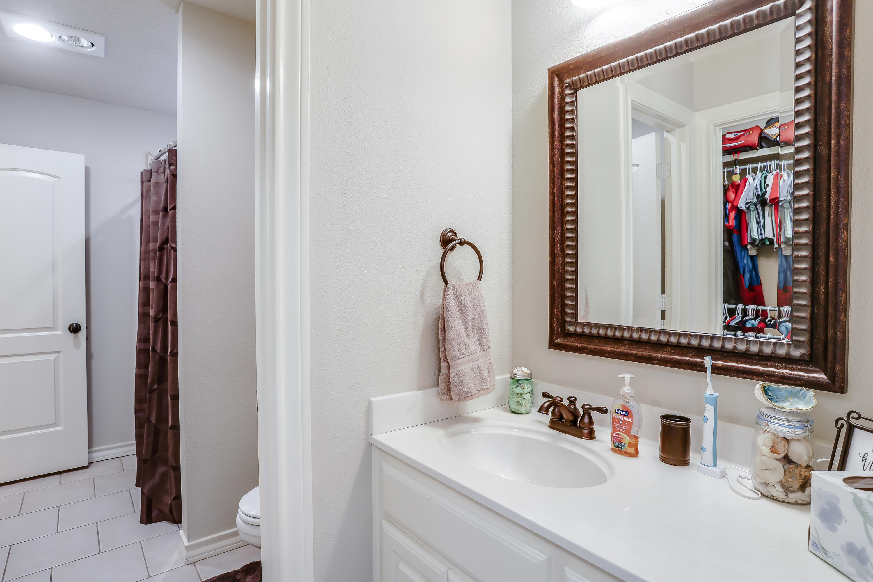 3804 103rd Street Lubbock, TX 79423 - Photo 22 of 32 a bathroom with a sink and a mirror