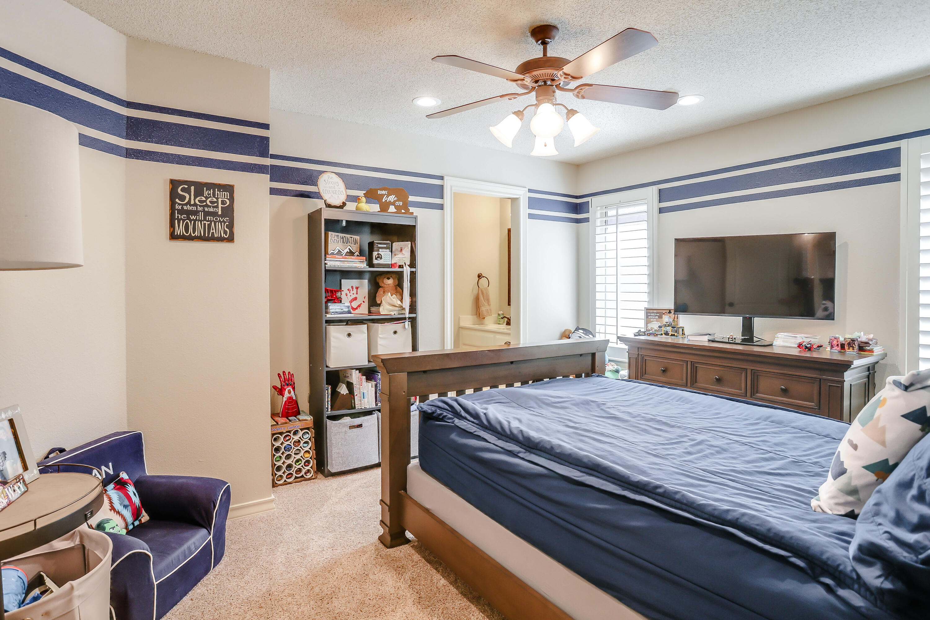 3804 103rd Street Lubbock, TX 79423 - Photo 23 of 32 a bedroom with a bed and a flat screen tv