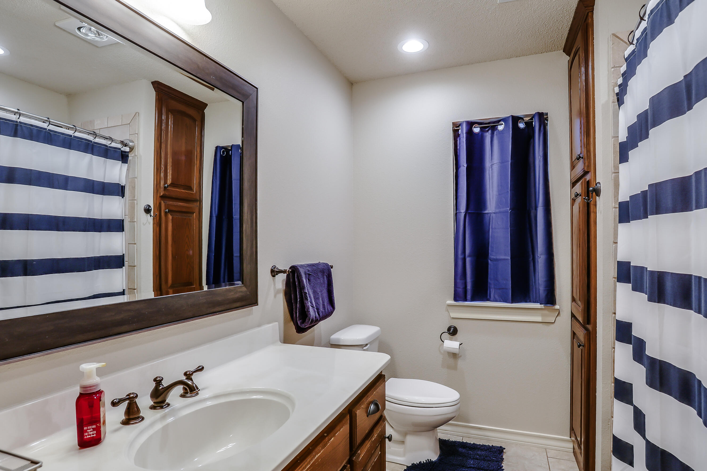 3804 103rd Street Lubbock, TX 79423 - Photo 27 of 32 a bathroom with a sink and a mirror