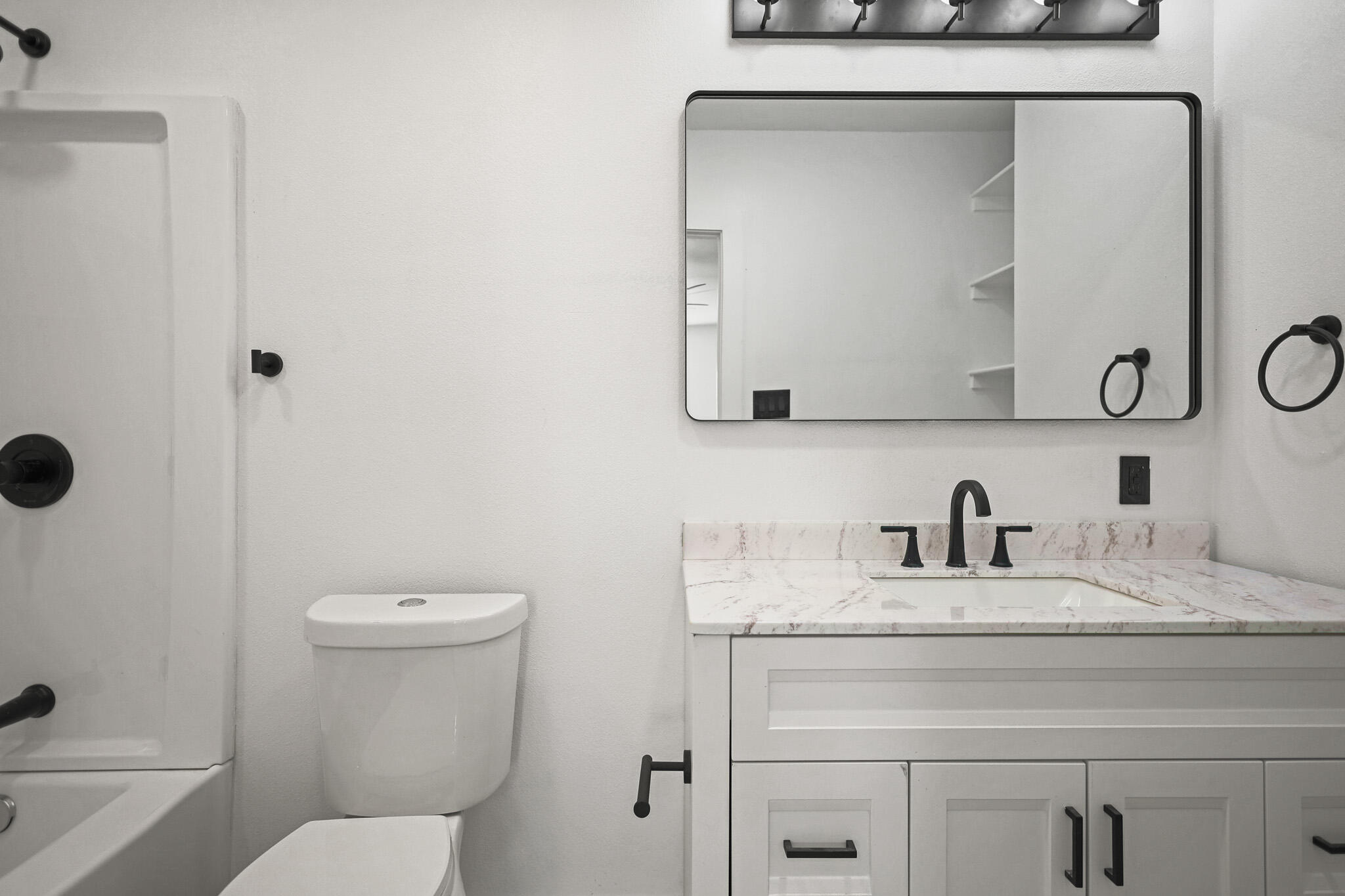 5512 45th Street Lubbock, TX 79414 - Photo 17 of 30 a bathroom with a toilet sink and mirror