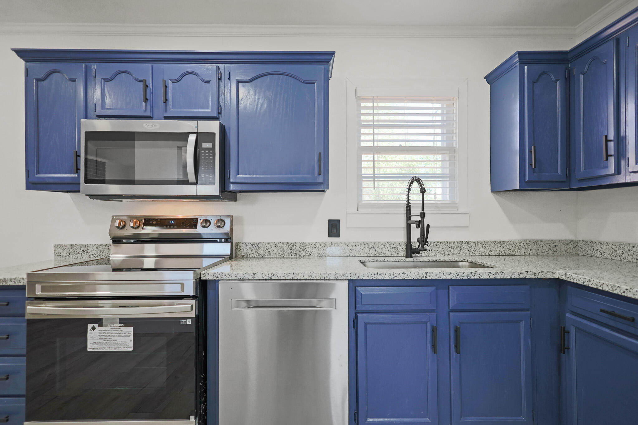 5512 45th Street Lubbock, TX 79414 - Photo 10 of 30 a kitchen with granite countertop a stove microwave and sink