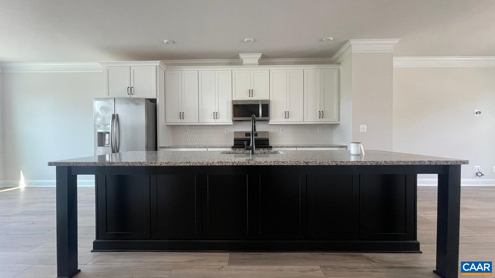4006 Varick Street Charlottesville, VA 22901 - Photo 6 of 33 a kitchen with granite countertop a black stove top oven and white cabinets