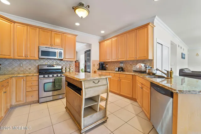 a kitchen with stainless steel appliances granite countertop a refrigerator and a stove top oven
