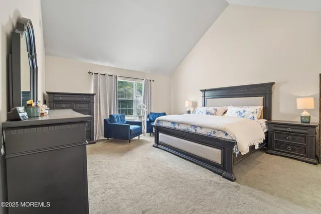 a bedroom with a bed and large windows