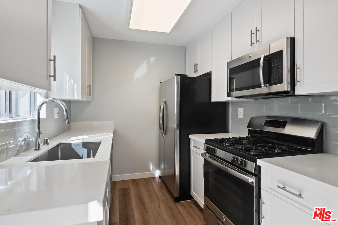 29239 Heathercliff Road, Unit 12 Malibu, CA 90265 - Photo 16 of 32 a kitchen with stainless steel appliances a stove a microwave a sink and cabinets