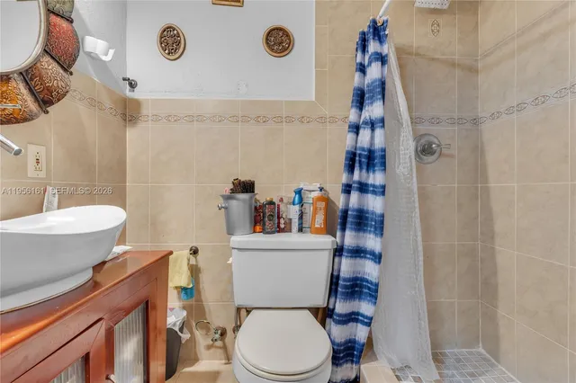 a white toilet sitting next to a bathroom sink and a shower