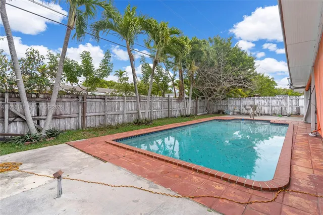 a view of a backyard with table and chairs under an umbrella
