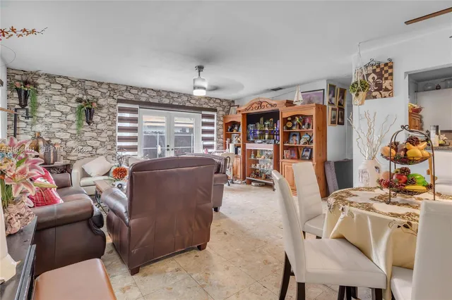 a living room with furniture a flat screen tv and a floor to ceiling window