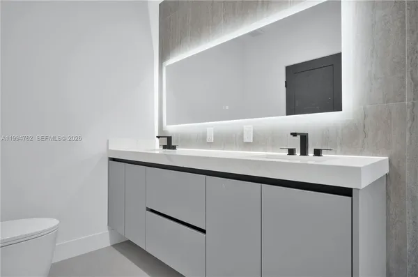 a bathroom with a sink toilet and mirror