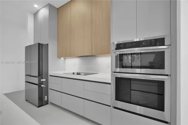 a kitchen with granite countertop white cabinets stainless steel appliances and counter space