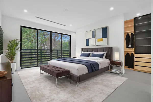 a bedroom with a large bed and a balcony view