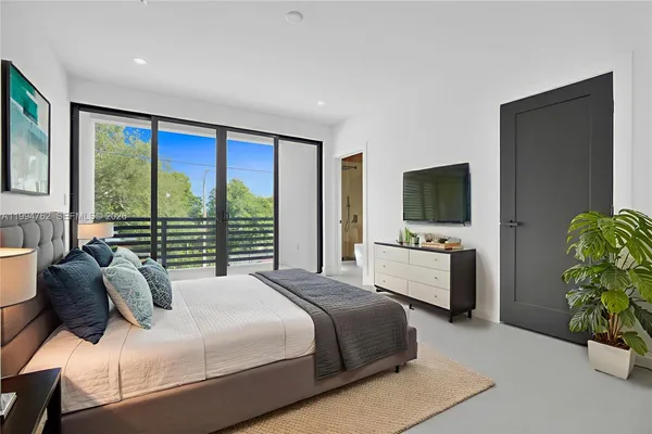 a bedroom with a bed and a flat screen tv